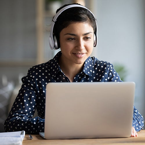 Woman with headphones on laptop